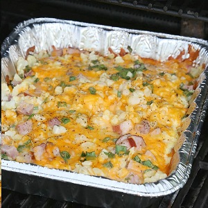 A variety of campfire meals including foil packet dinners, campfire breakfasts, and campfire desserts cooking over a fire.