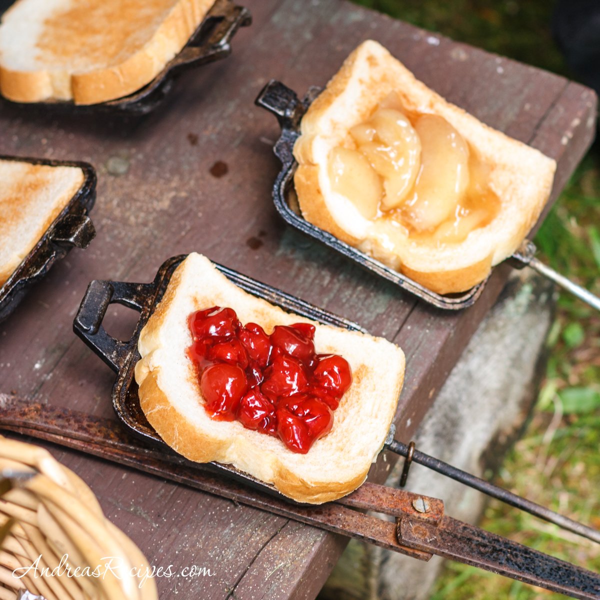 A variety of campfire meals including foil packet dinners, campfire breakfasts, and campfire desserts cooking over a fire.