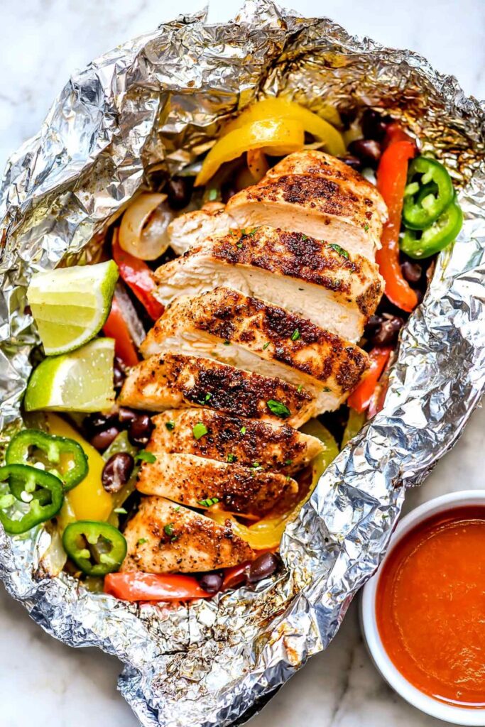 A variety of colorful and delicious foil packets for the oven featuring chicken foil packets, vegetable foil packets, and seafood foil packets in aluminum foil.