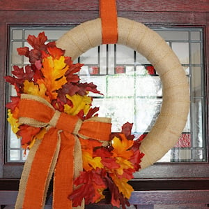 burlap wreath with fall leaves and orange ribbon