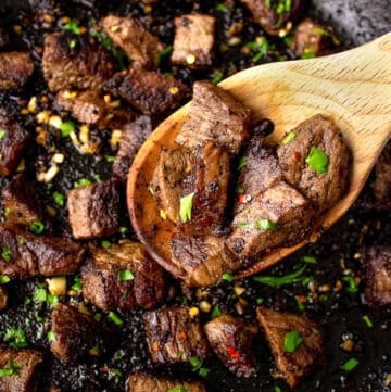 garlic butter steak bites on a wooden spoon