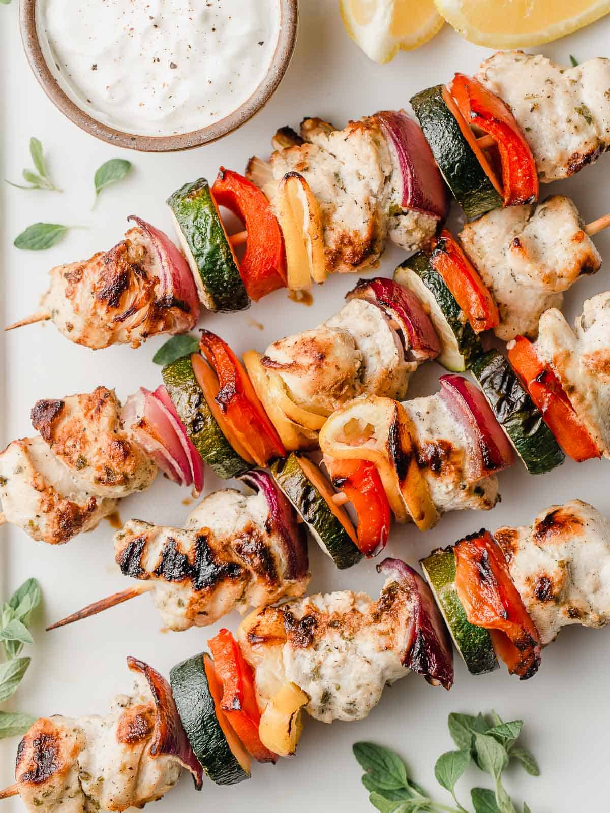 Homemade greek chicken kabobs on a serving platter