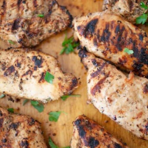 Grilled chicken on a cutting board.